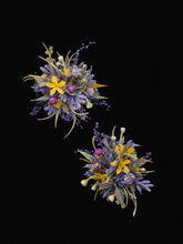 Two Dreamy Purple Green Wedding Flower Rings by CAMELLIA feature colorful floral arrangements with yellow, purple, and white flowers against a black background. The blooms resemble handcrafted designs that could inspire a custom wedding flower ring, perfect for an adjustable ring size.